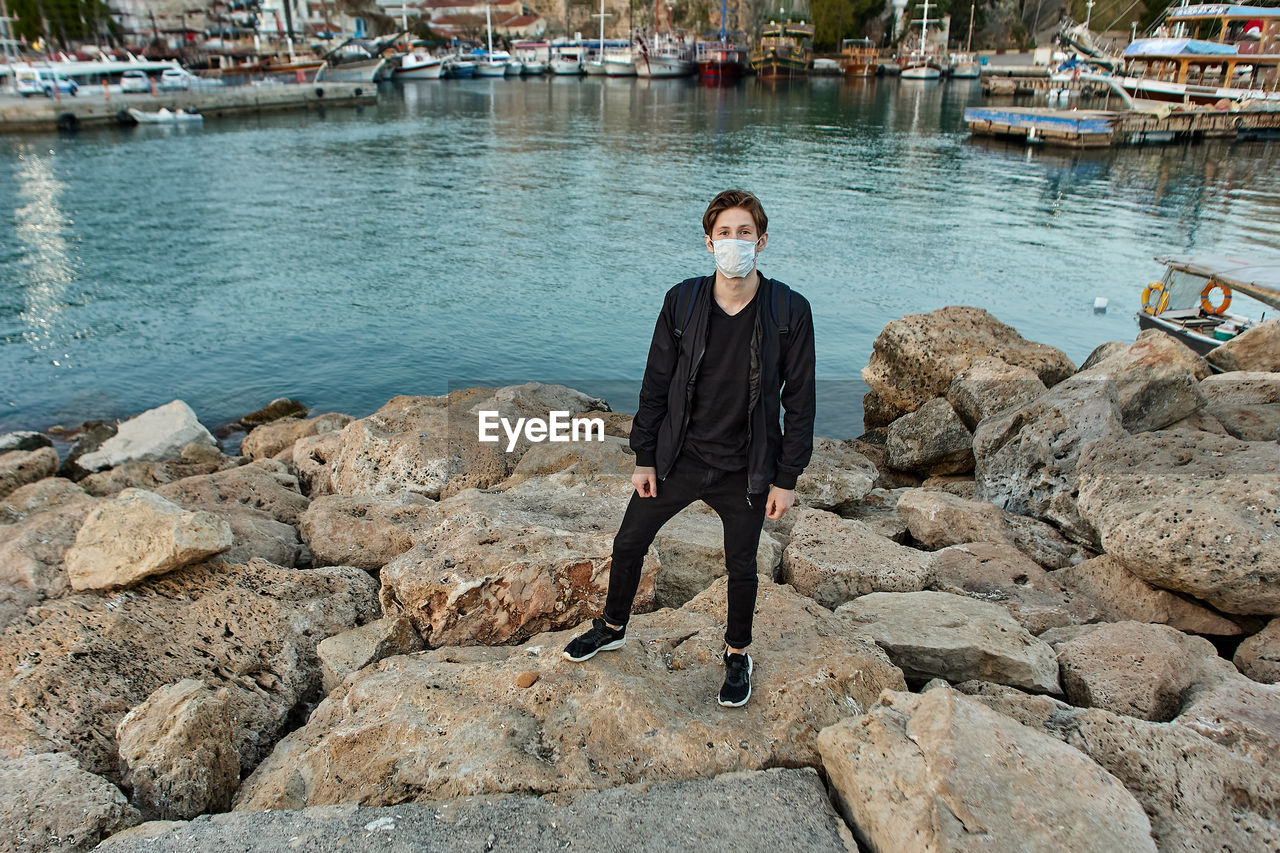FULL LENGTH OF MAN STANDING ON ROCKS