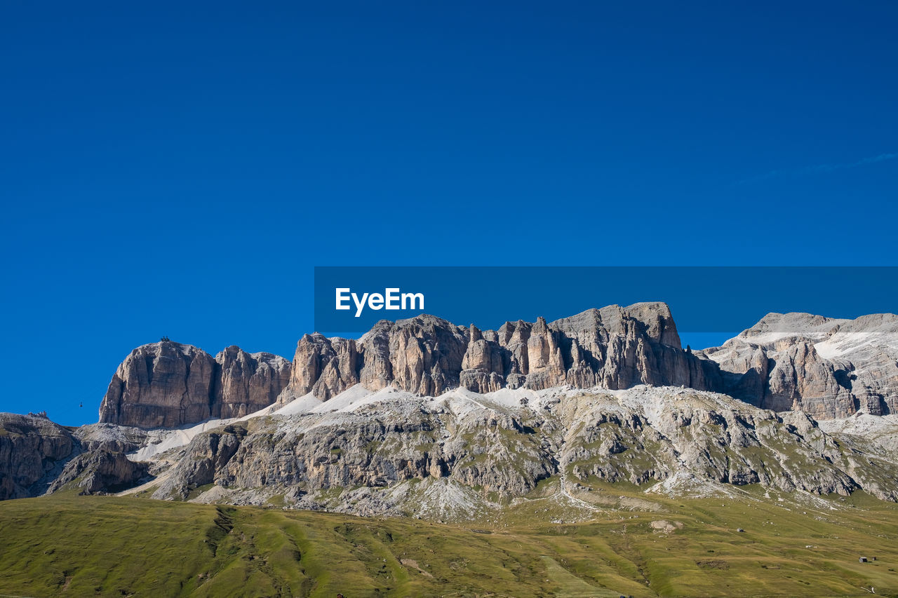 Rock formations on landscape against clear blue sky