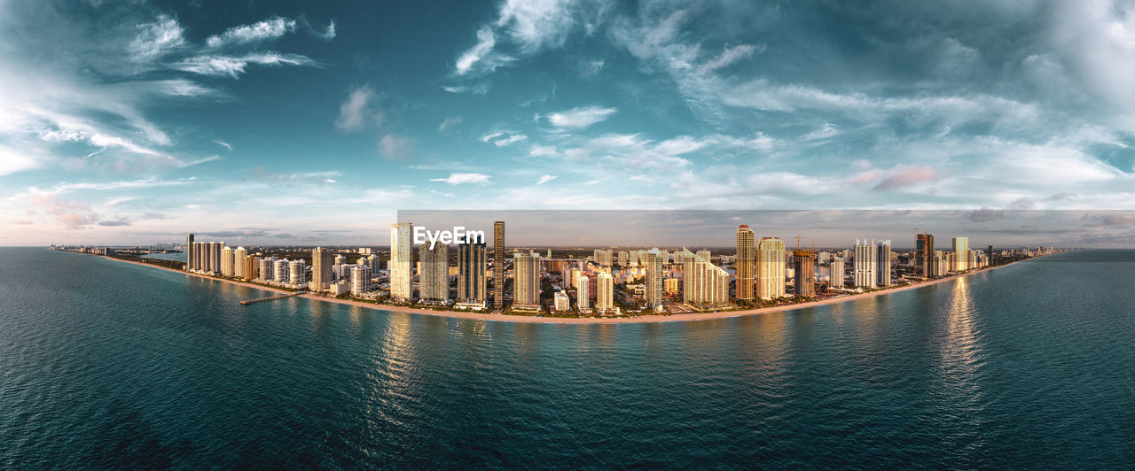 Panoramic view of sea and buildings against sky