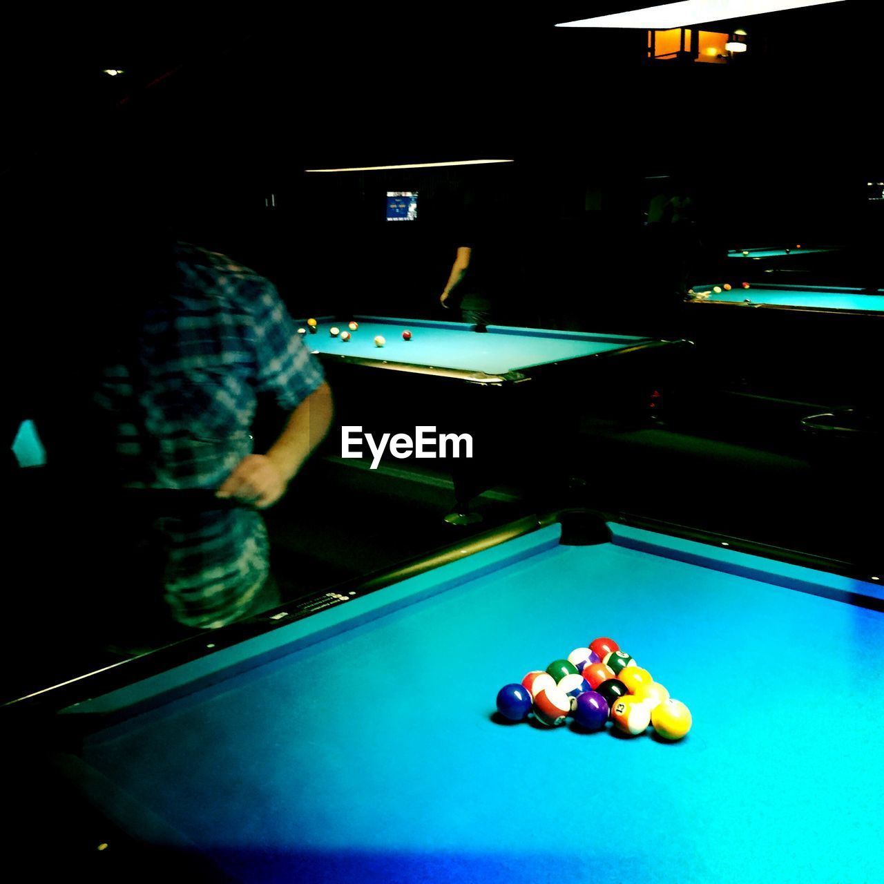 Man standing by pool table in hall