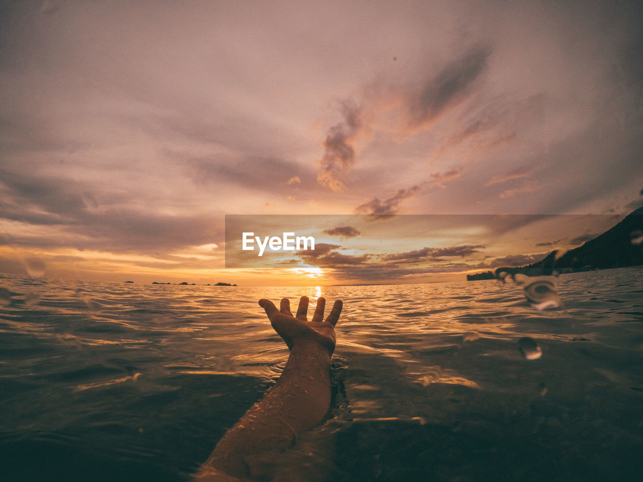 SHADOW OF HAND ON SEA SHORE