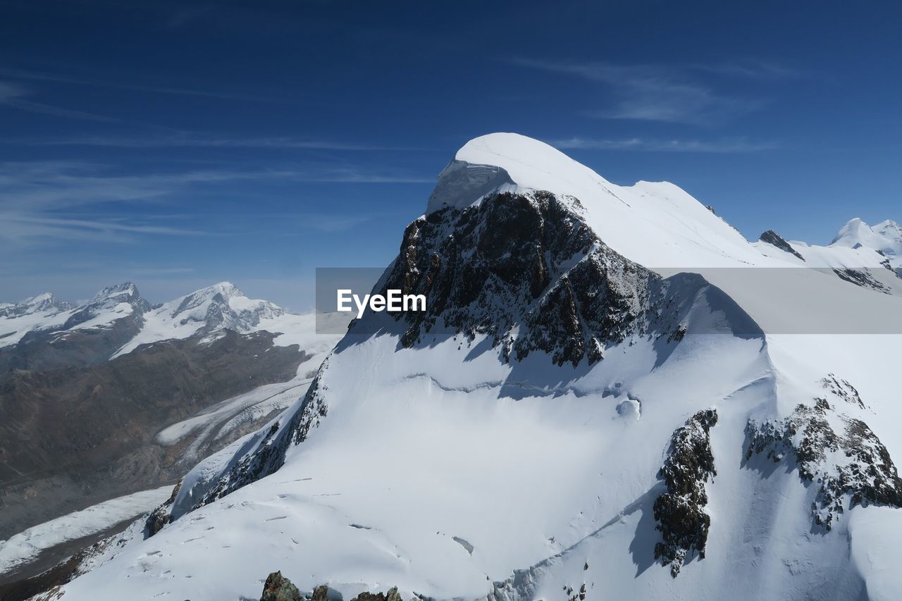 Low angle view of snowcapped mountains against sky