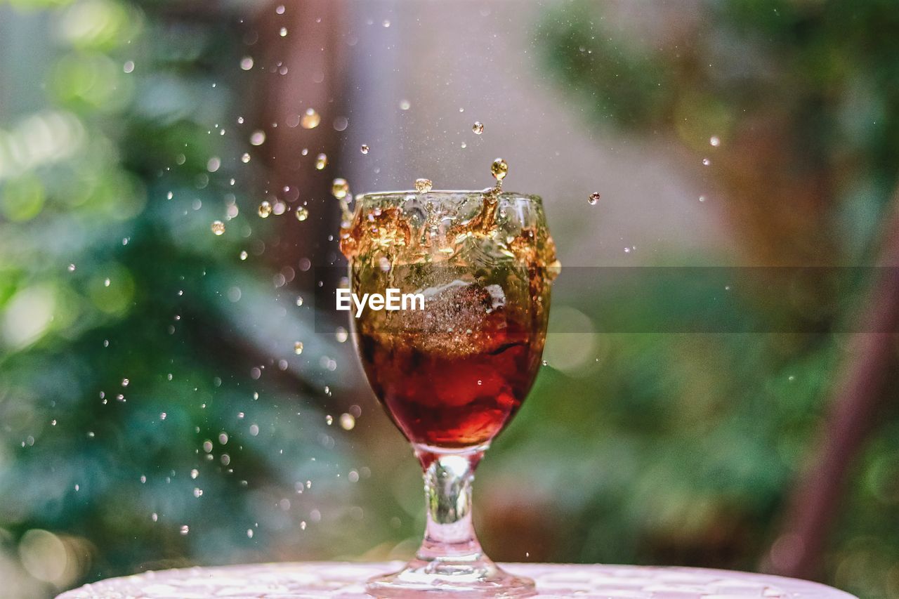 Close-up of drink splashing in glass on table