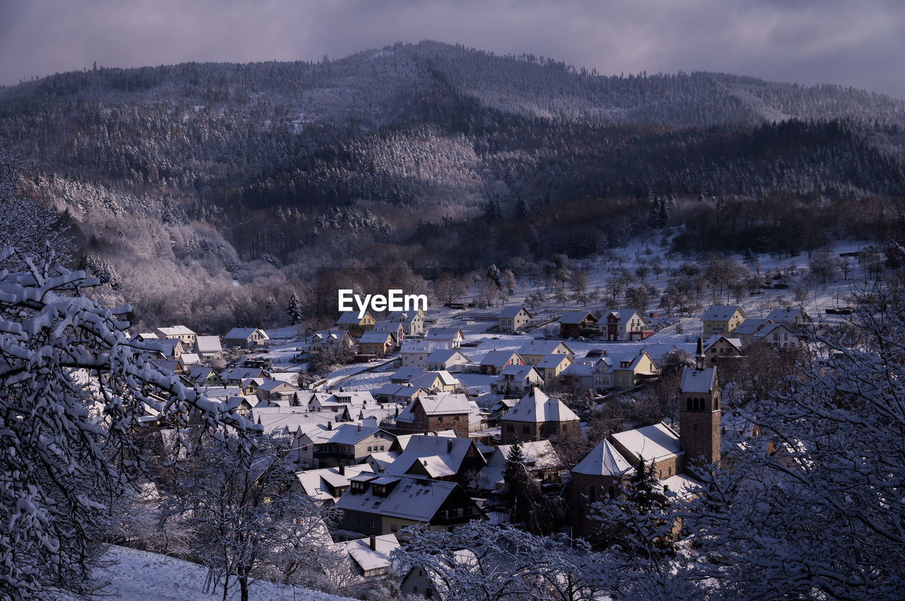 AERIAL VIEW OF BUILDINGS ON SNOWCAPPED MOUNTAIN