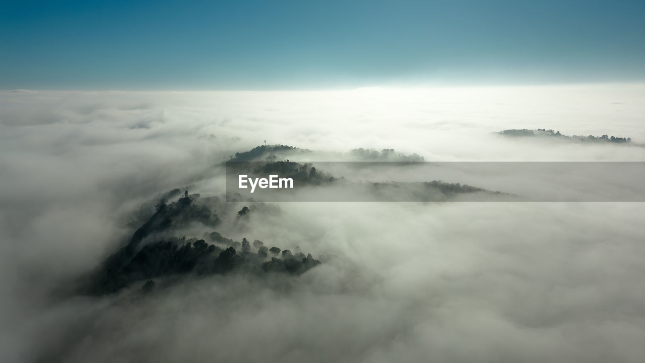 cloud, sky, environment, scenics - nature, fog, beauty in nature, mountain, nature, landscape, cloudscape, mist, no people, travel, tranquility, high up, outdoors, mountain range, aerial view, idyllic, blue, tranquil scene, horizon, snow, awe, land, sunlight, morning, copy space, day, dramatic sky, mountain peak, cold temperature, non-urban scene, atmospheric mood, high angle view, travel destinations, winter, atmosphere