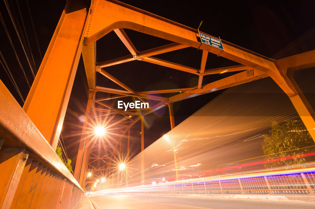 Low angle view of illuminated bridge at night