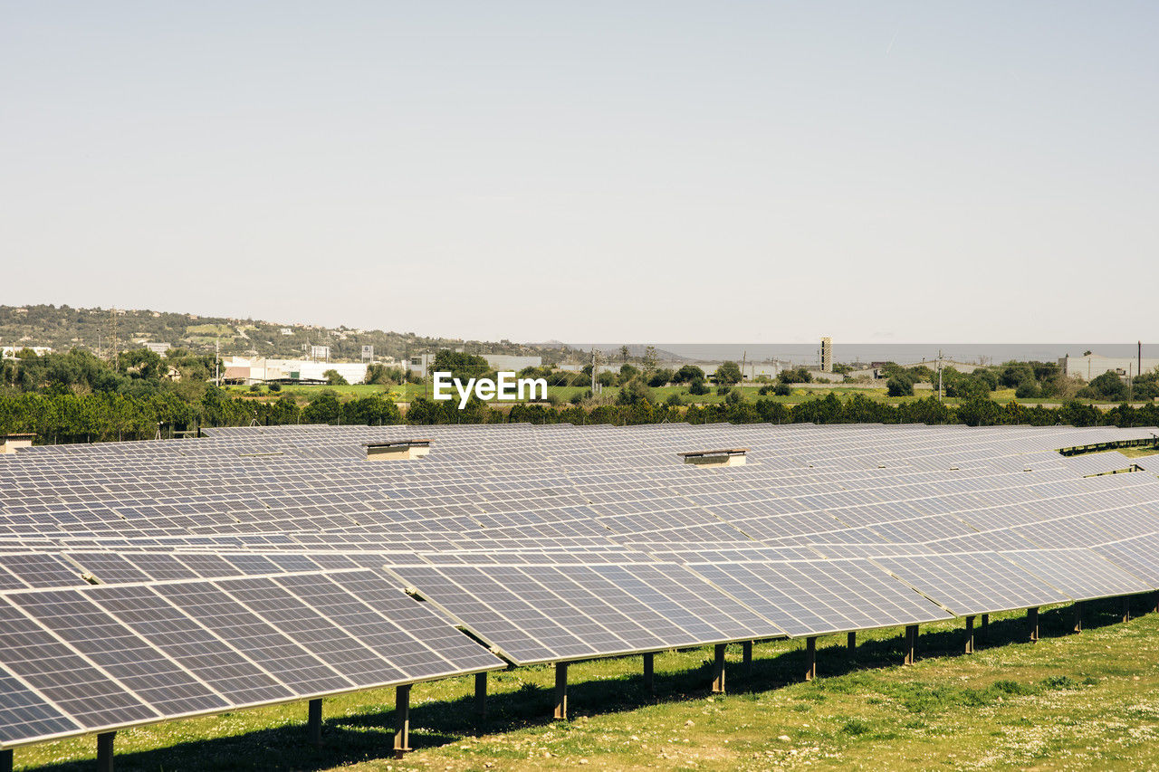 Solar panels in rows against sky at power station