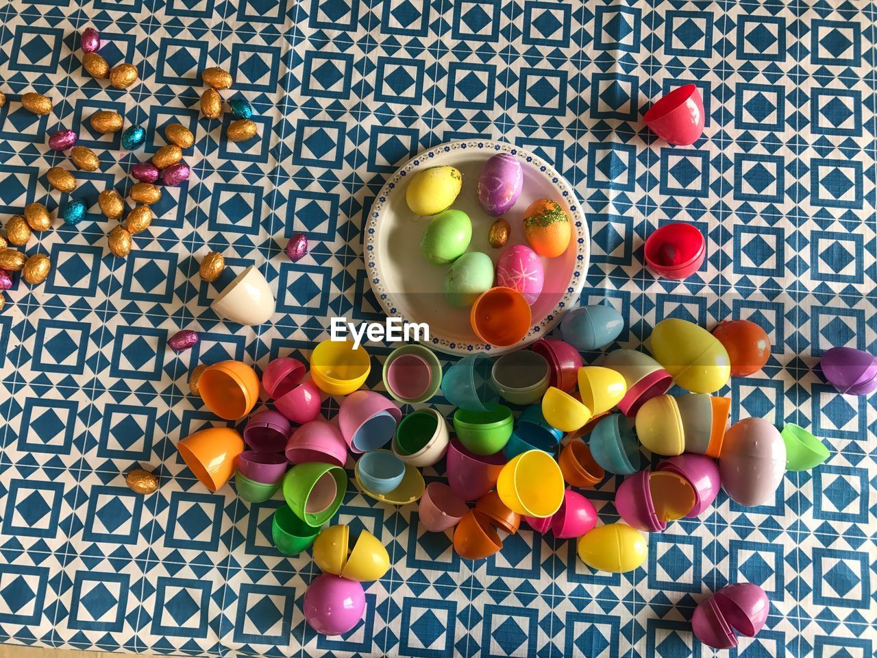 High angle view of colorful easter eggs with chocolates on table