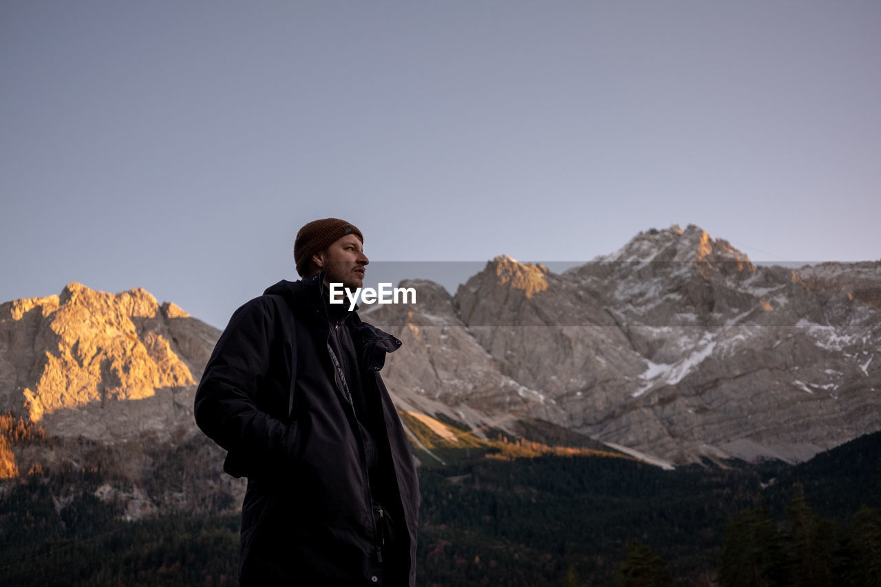 Man standing on rocks against mountain range