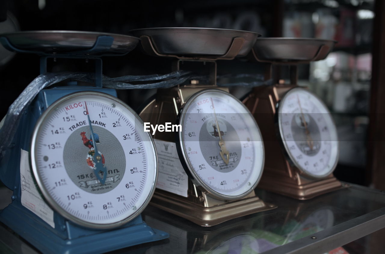 Close-up of weight scales on display cabinet at store