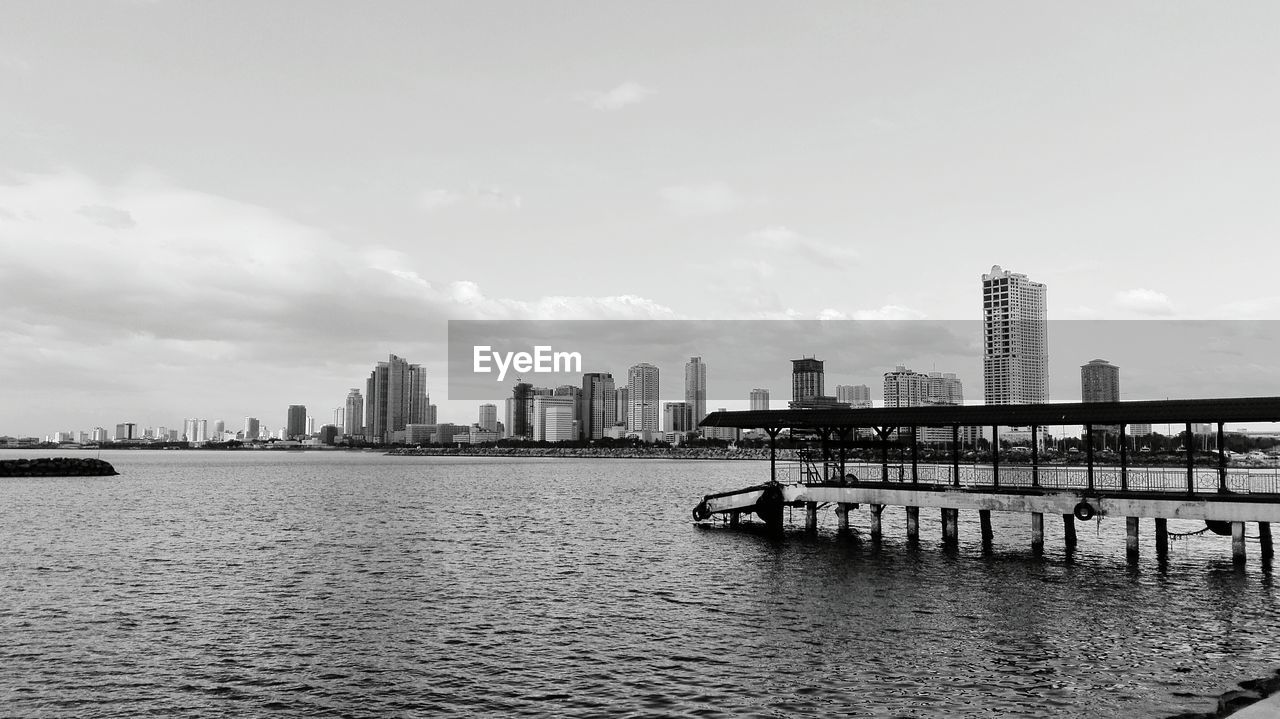 Scenic view of river by city against sky