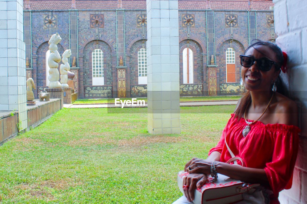 Portrait of smiling woman sitting at historic place