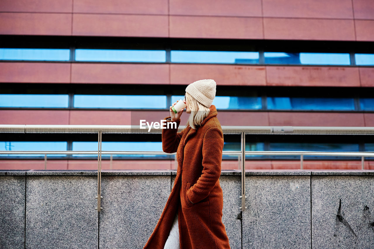 Woman at city street with coffee cup