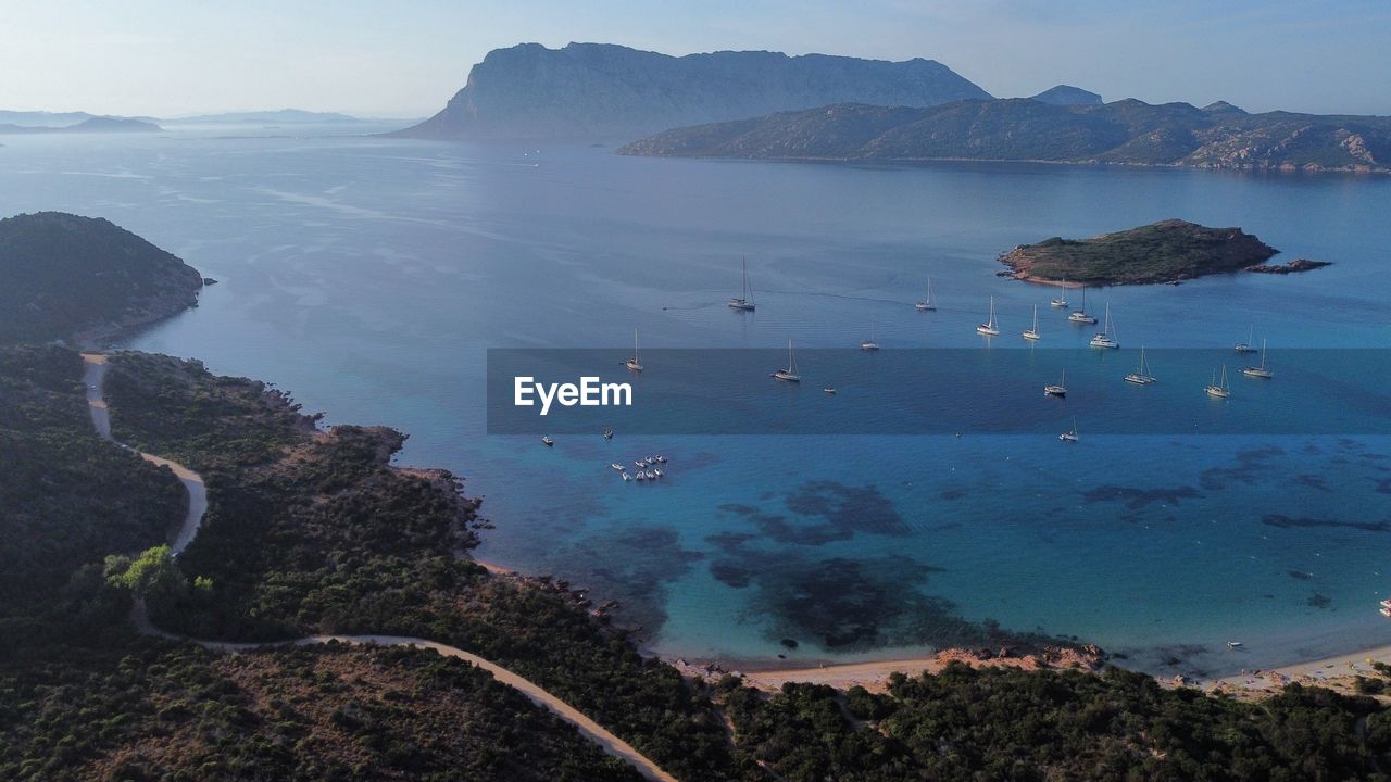 water, sea, land, coast, scenics - nature, mountain, environment, nature, sky, landscape, beauty in nature, bay, travel, beach, travel destinations, body of water, ocean, tranquility, blue, island, no people, coastline, terrain, shore, outdoors, aerial photography, tourism, transportation, tranquil scene, cliff, rock, aerial view, day, bay of water, lagoon, high angle view, cloud, trip, vacation, nautical vessel, mountain range, holiday, volcano, horizon, archipelago, non-urban scene