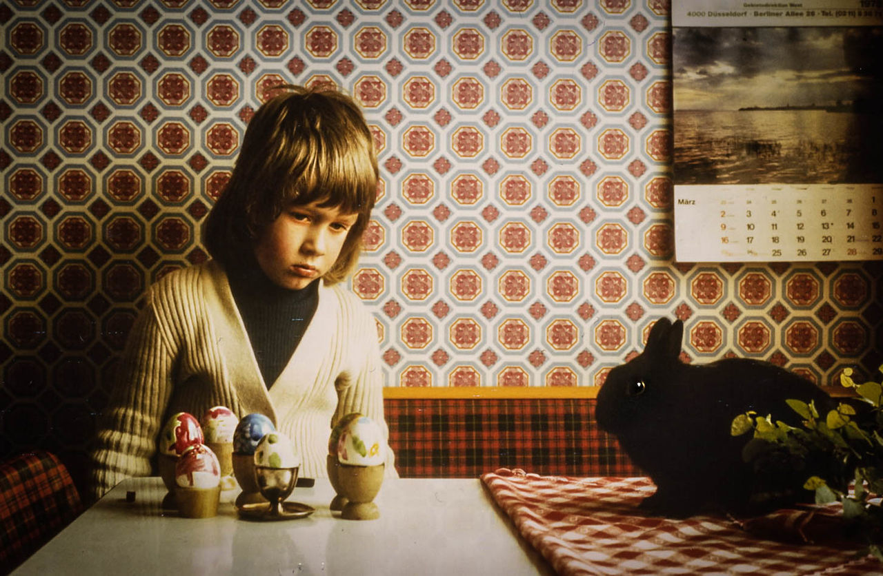 Boy looking easter eggs on table at home