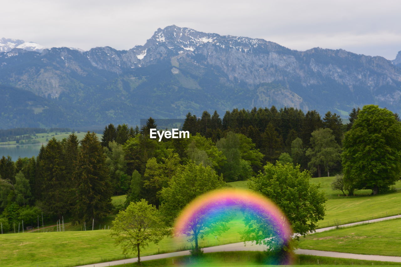 Scenic view of rainbow over mountains against sky