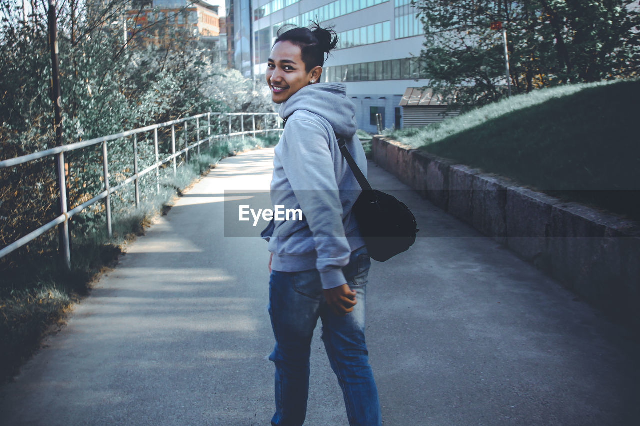 Smiling man walking on road in city