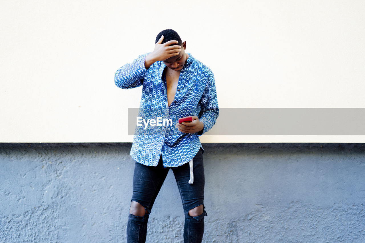 Young african man playing on his smartphone