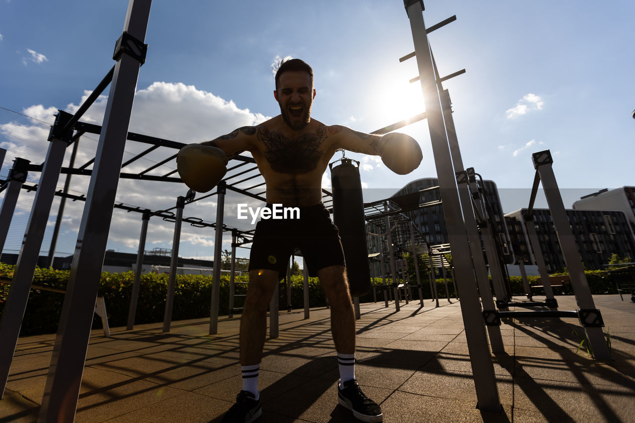 Man in boxing gloves is practicing on an outdoor