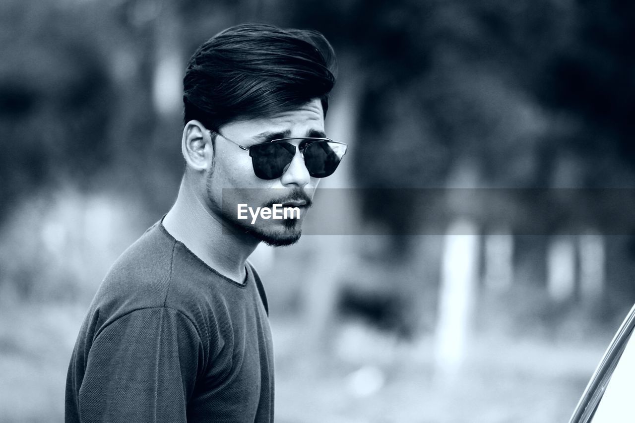 Portrait of young man wearing sunglasses standing outdoors