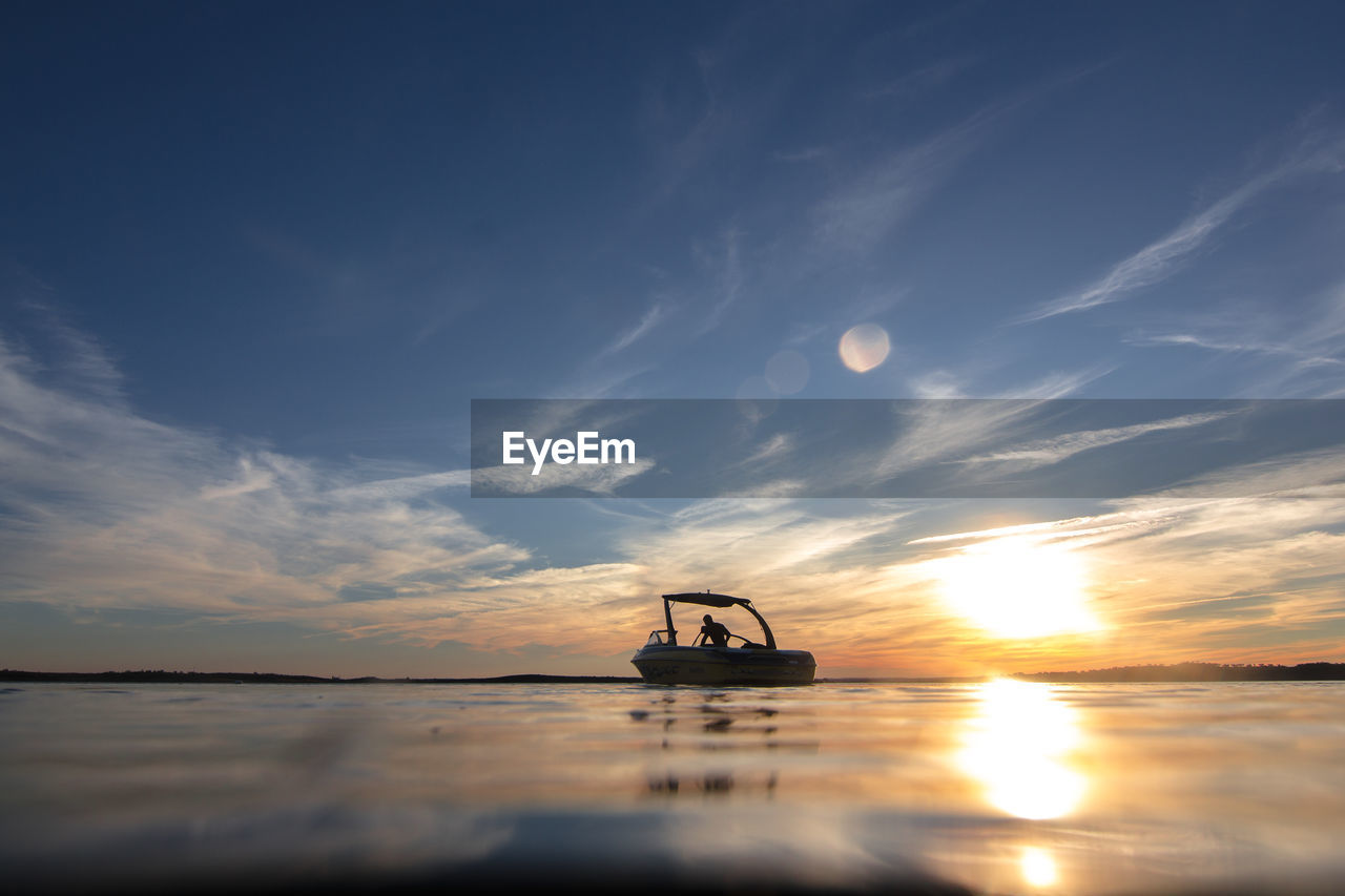 Silhouette of boat on sea against sky during sunset