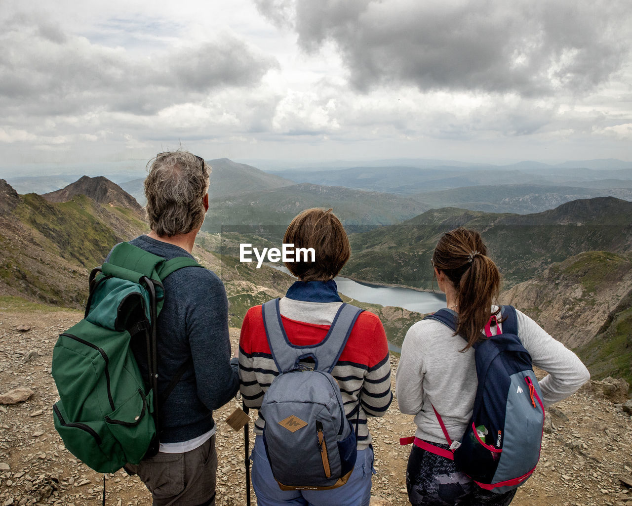 REAR VIEW OF WOMEN LOOKING AT MOUNTAIN RANGE