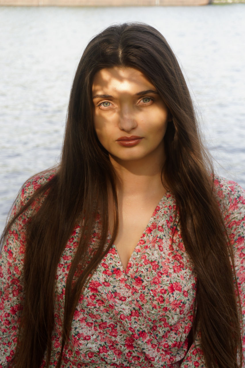 Portrait of young woman standing at beach