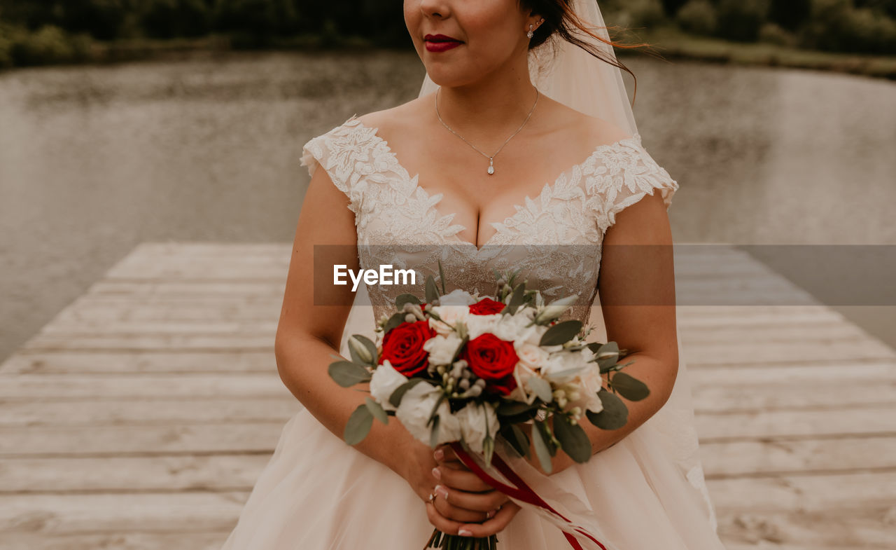 portrait of young woman standing by railing