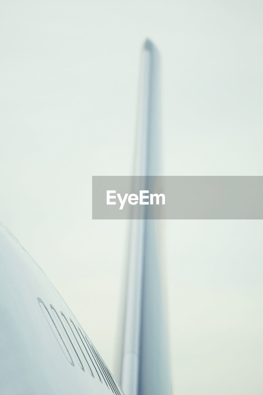 CLOSE-UP OF AIRPLANE WING AGAINST CLEAR SKY