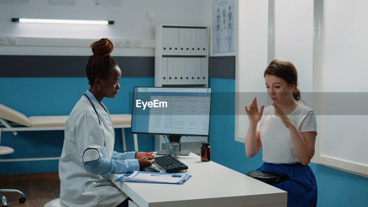 Doctor wearing mask examining patient in clinic