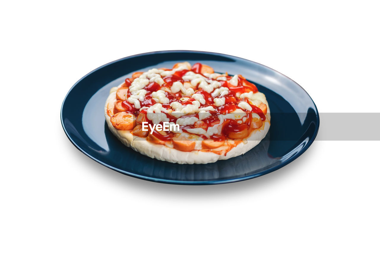 Sausage and crab stick pizza in a ceramic plate isolated on white background.