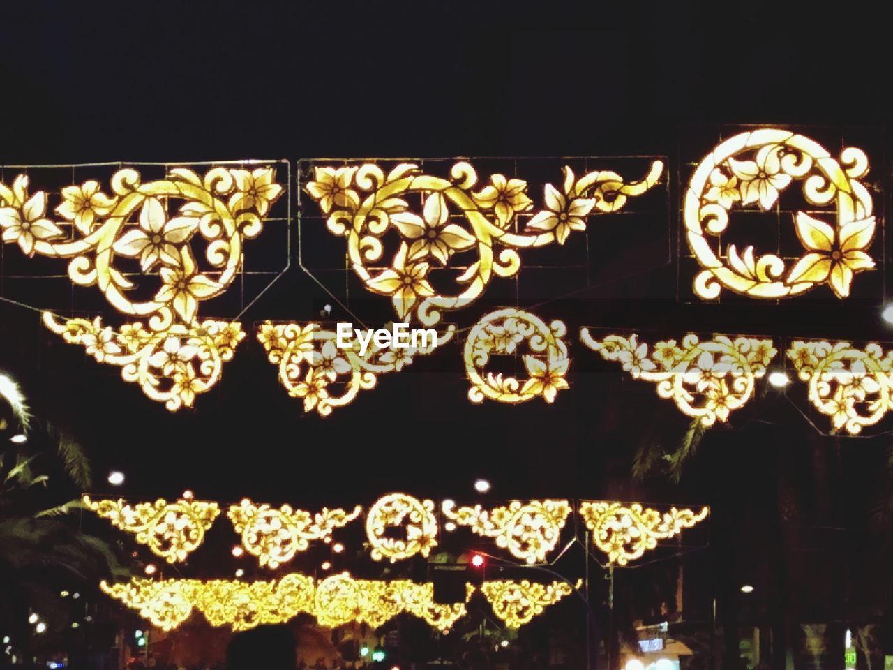 LOW ANGLE VIEW OF ILLUMINATED LIGHTING EQUIPMENT AGAINST DARK WALL