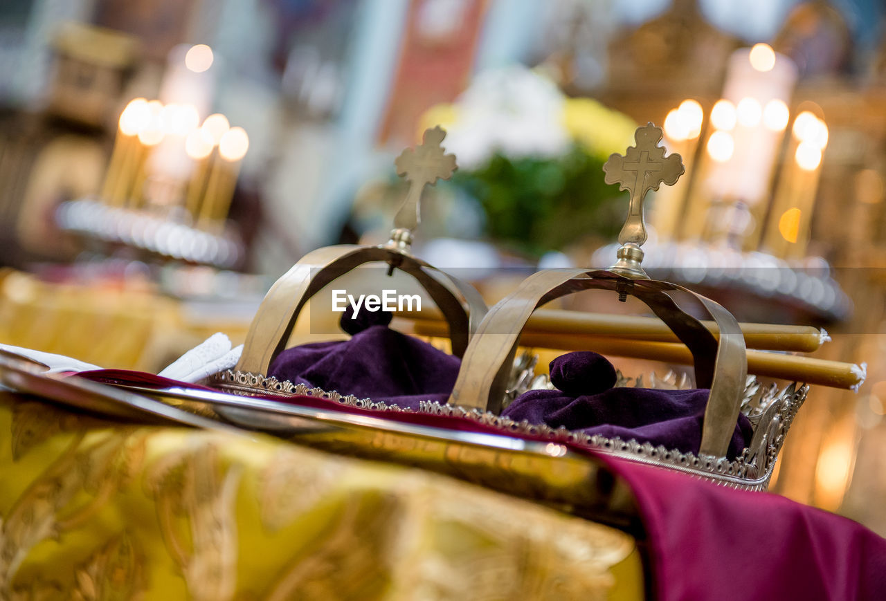 Close-up of crowns on table at orthodox wedding