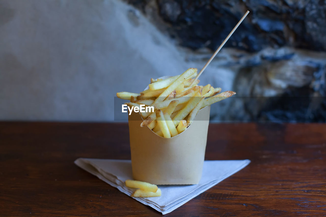 Close-up of french fries, or simply fries, chips, finger chips, or french-fried potatoes on table