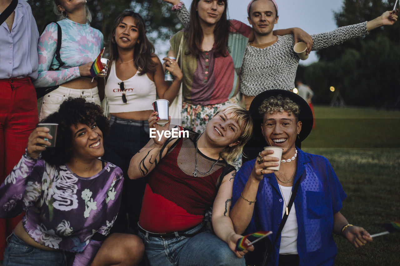 Portrait of happy friends enjoying together at park during sunset