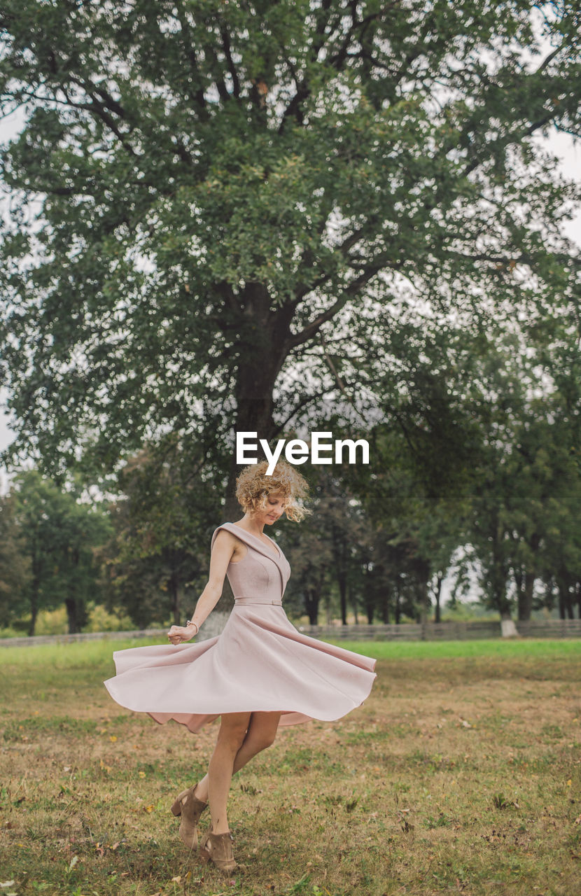 Full length of woman spinning on field in park