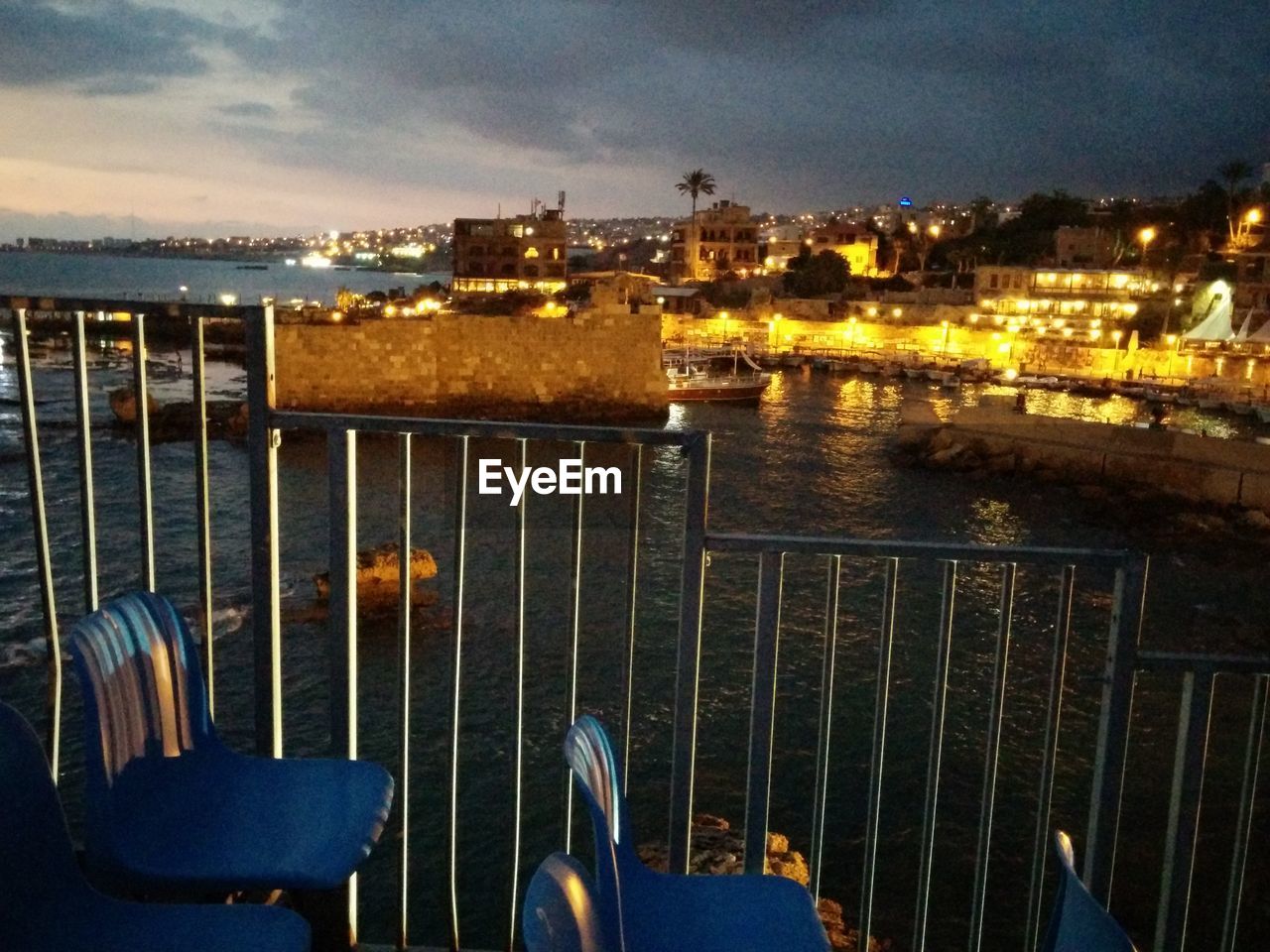 VIEW OF ILLUMINATED HARBOR AGAINST SKY