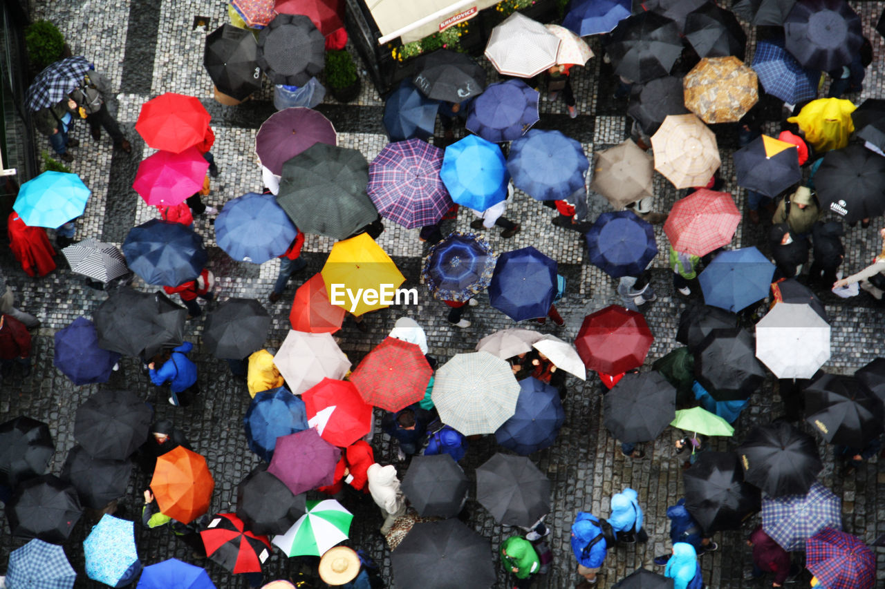 High angle view of people standing with umbrella on street during monsoon