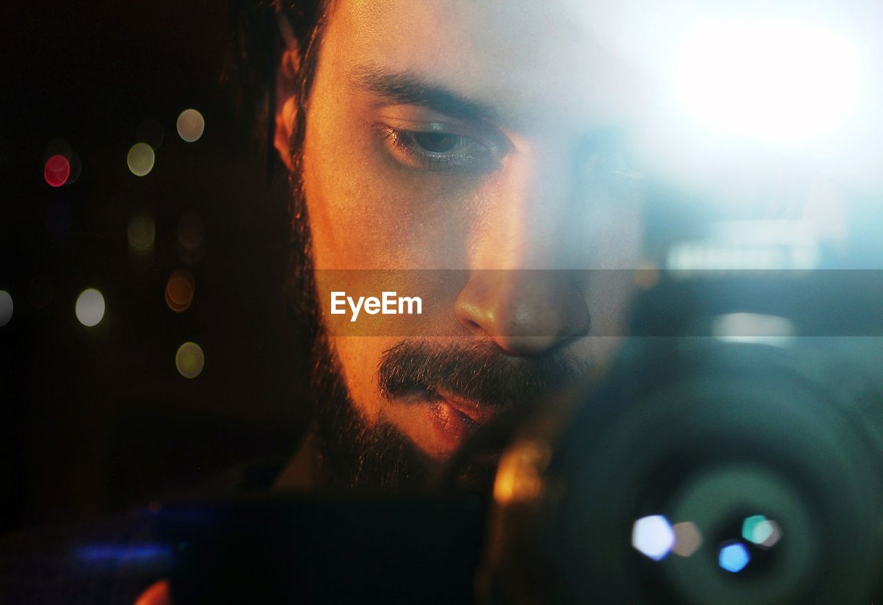 Close-up of young man photographing through camera