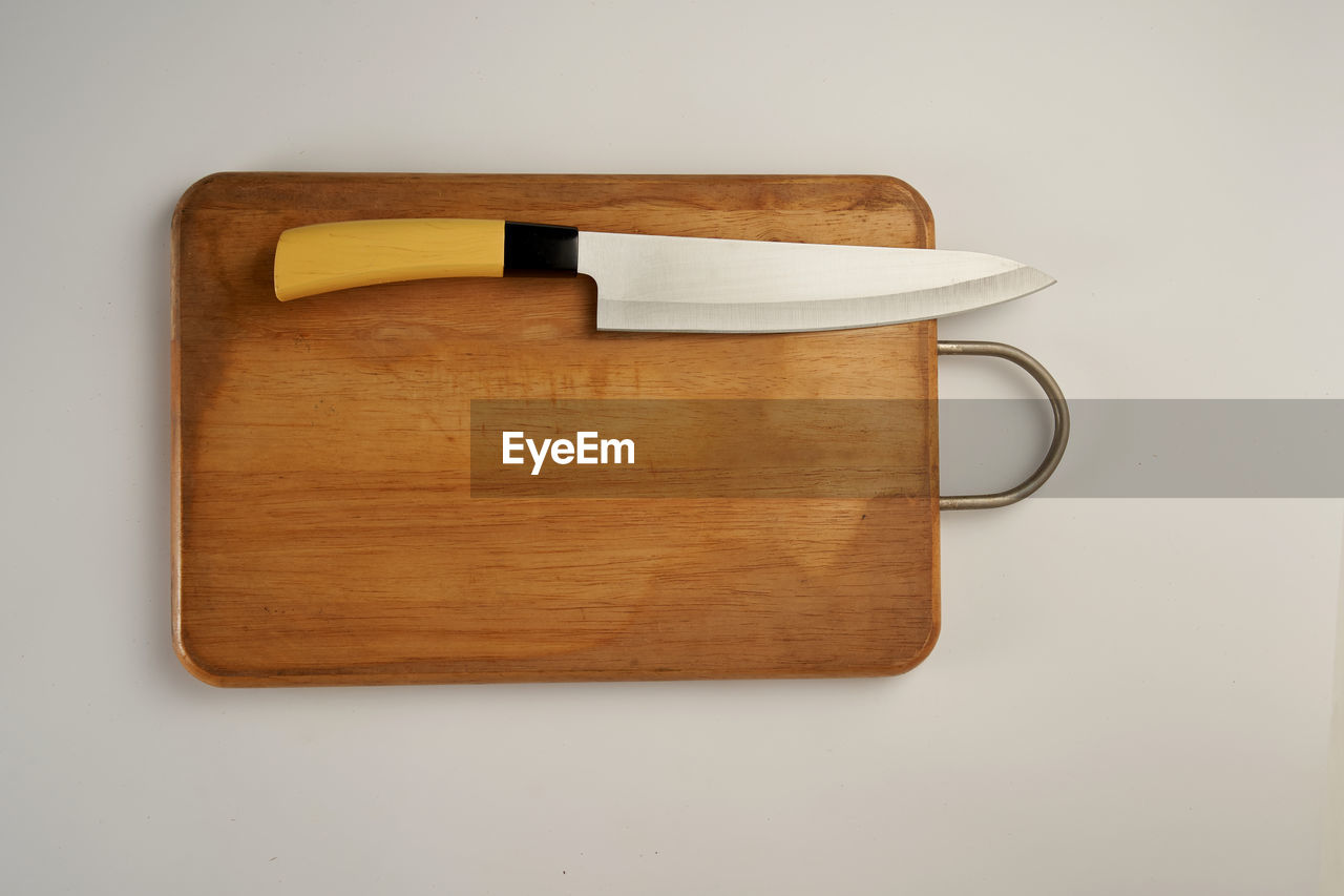 Kitchen knife and chopping board on whitte background