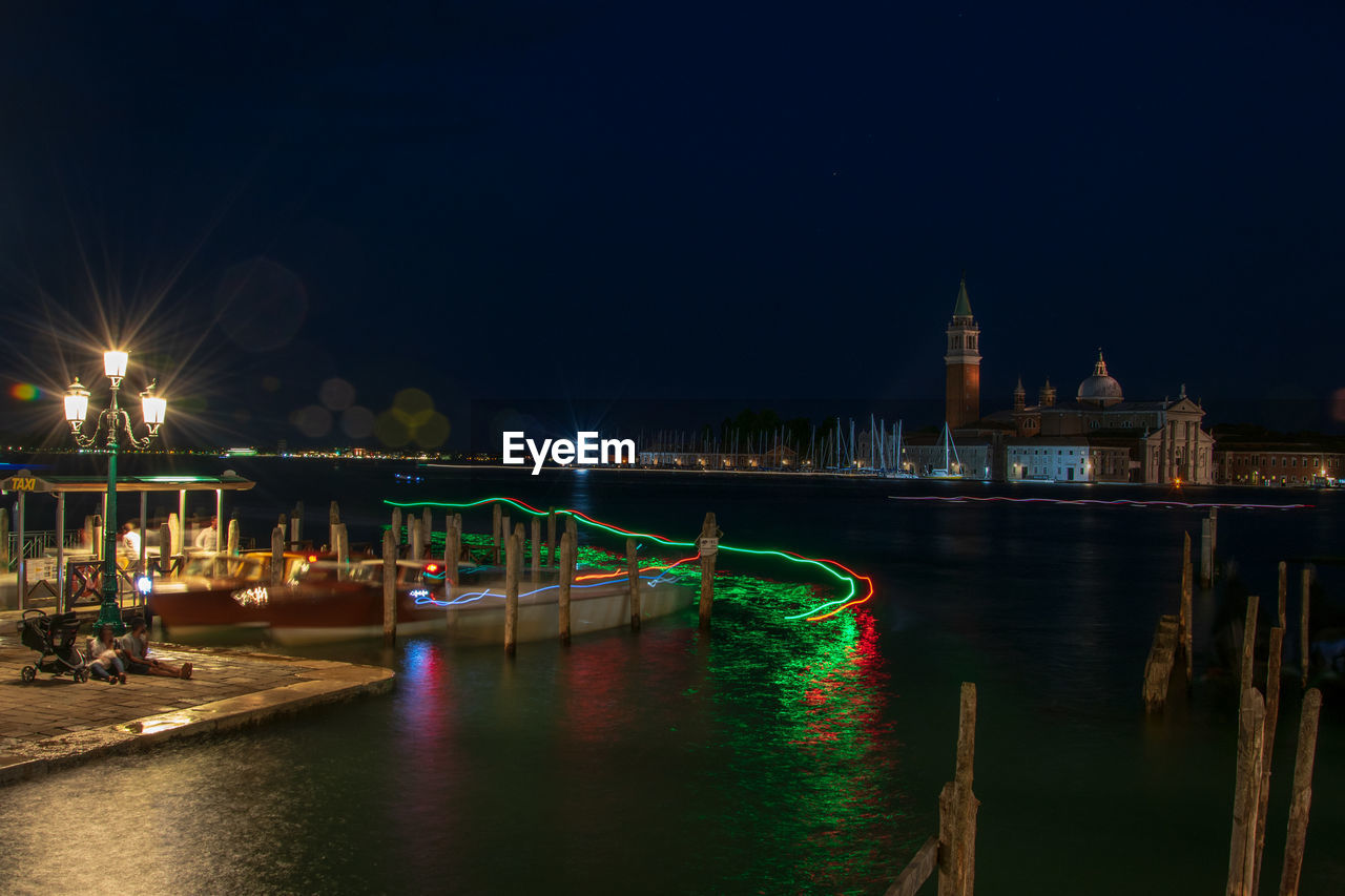 ILLUMINATED BRIDGE OVER RIVER IN CITY