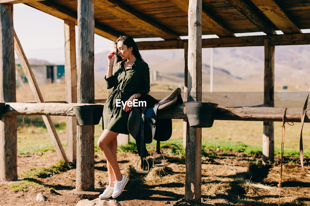 Full length of woman standing by stable