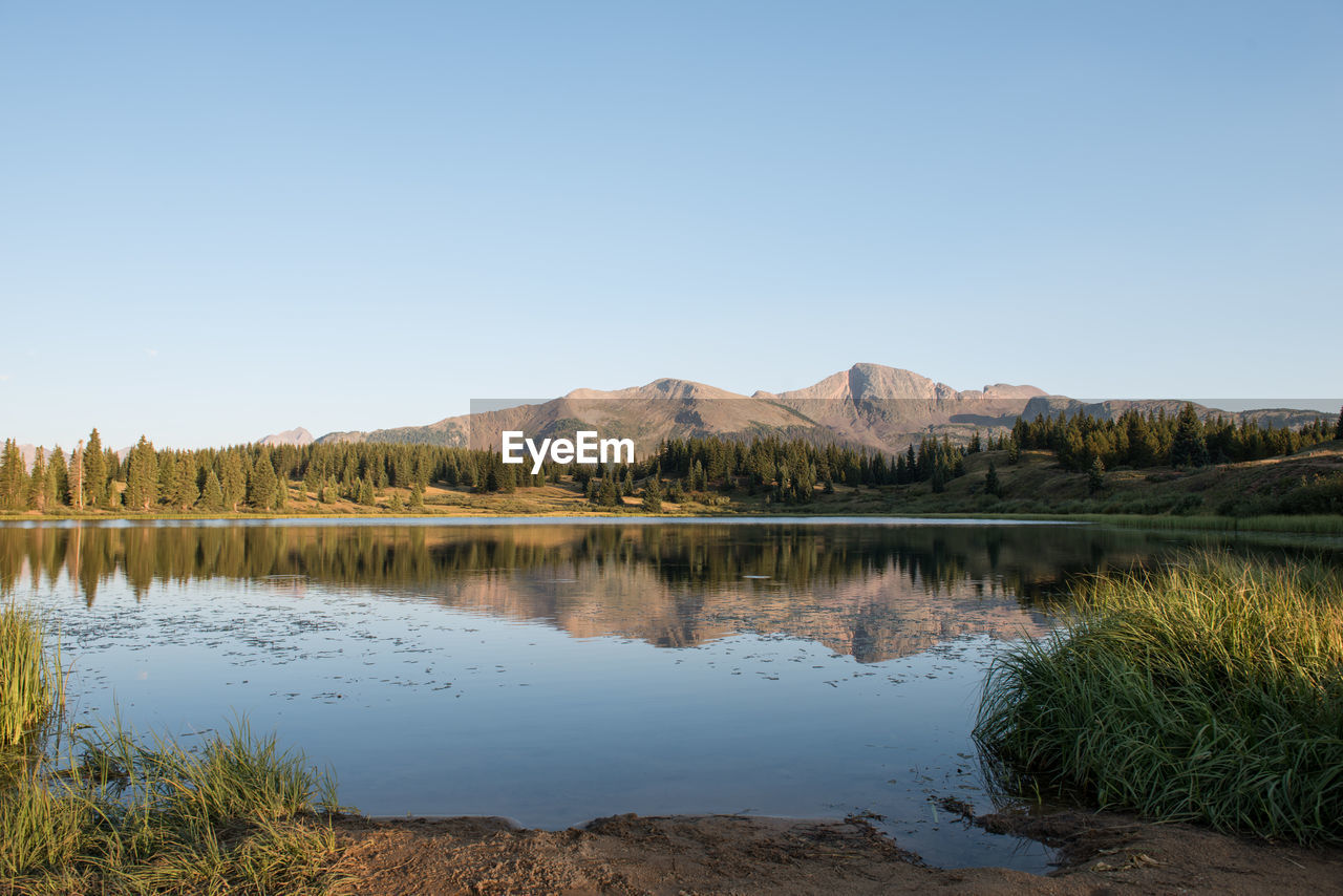 Scenic view of lake against clear blue sky