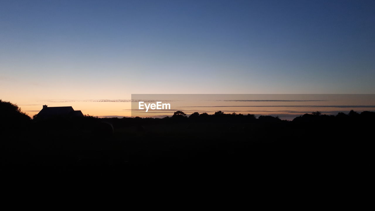 Scenic view of silhouette landscape against clear sky at sunset