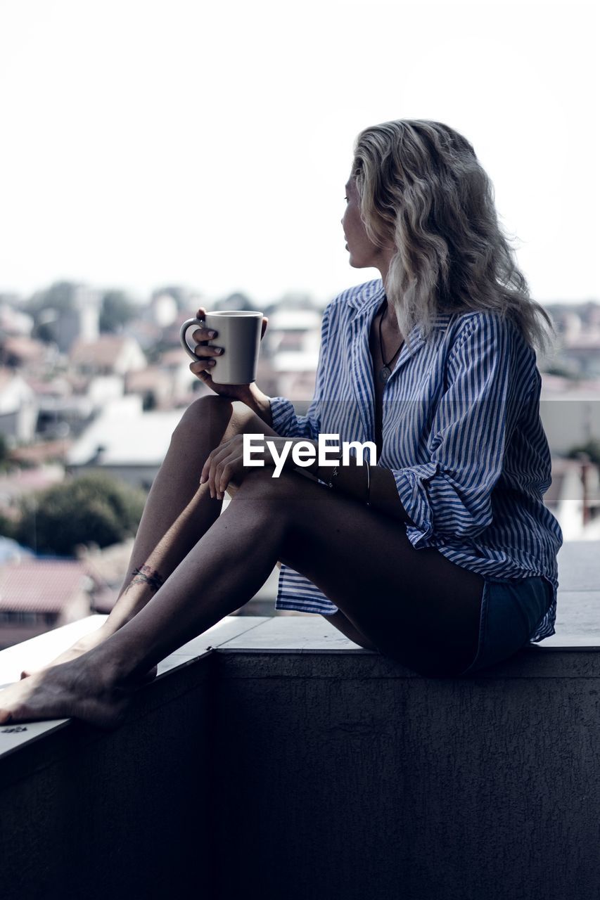 WOMAN SITTING IN COFFEE CUP