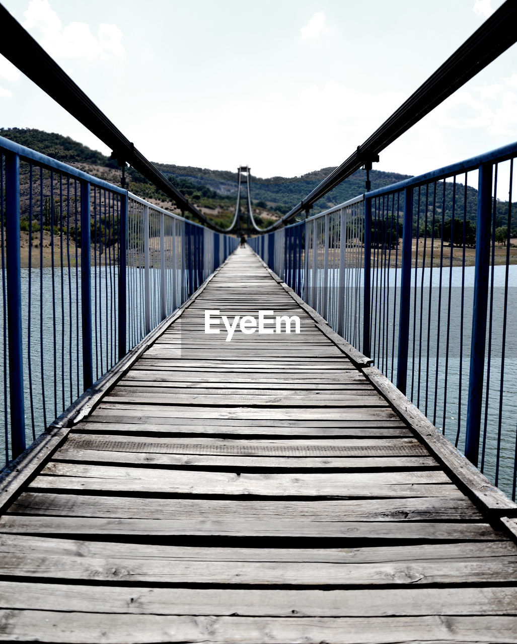 VIEW OF FOOTBRIDGE AGAINST CLOUDY SKY