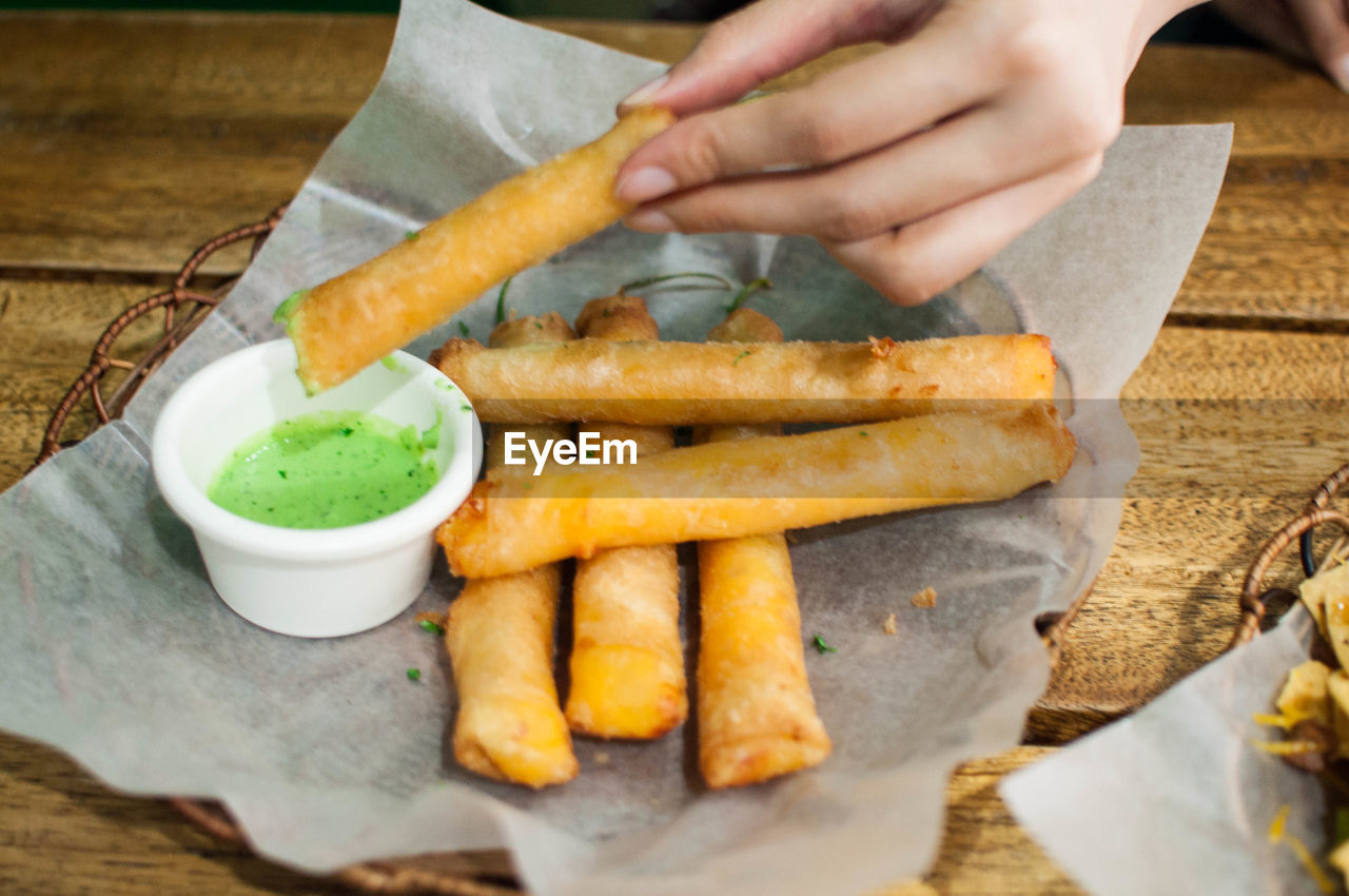 Cropped hand holding food on table