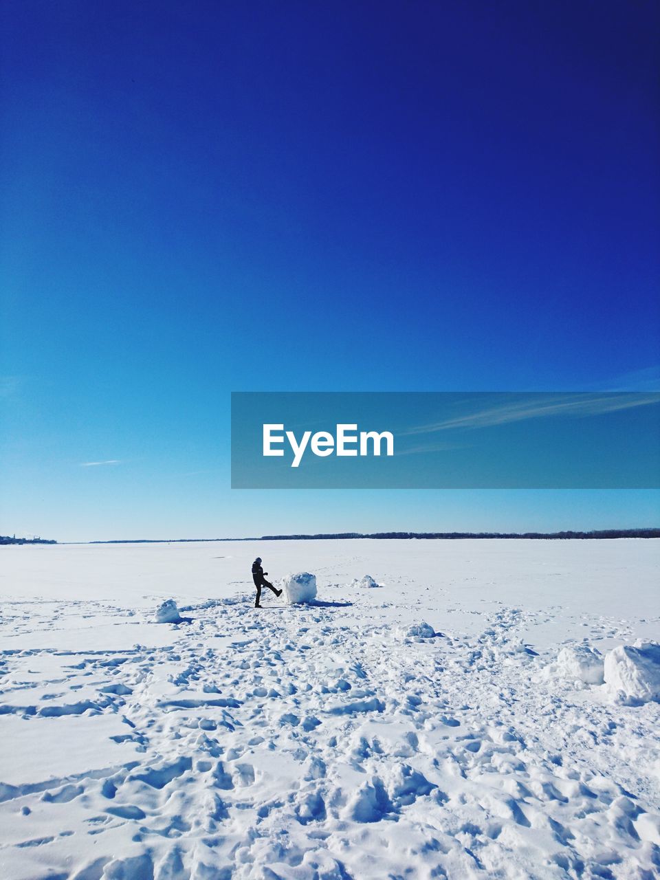 Man on snowcapped mountain against clear blue sky