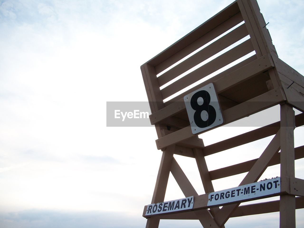 Low angle view of number on chair against sky