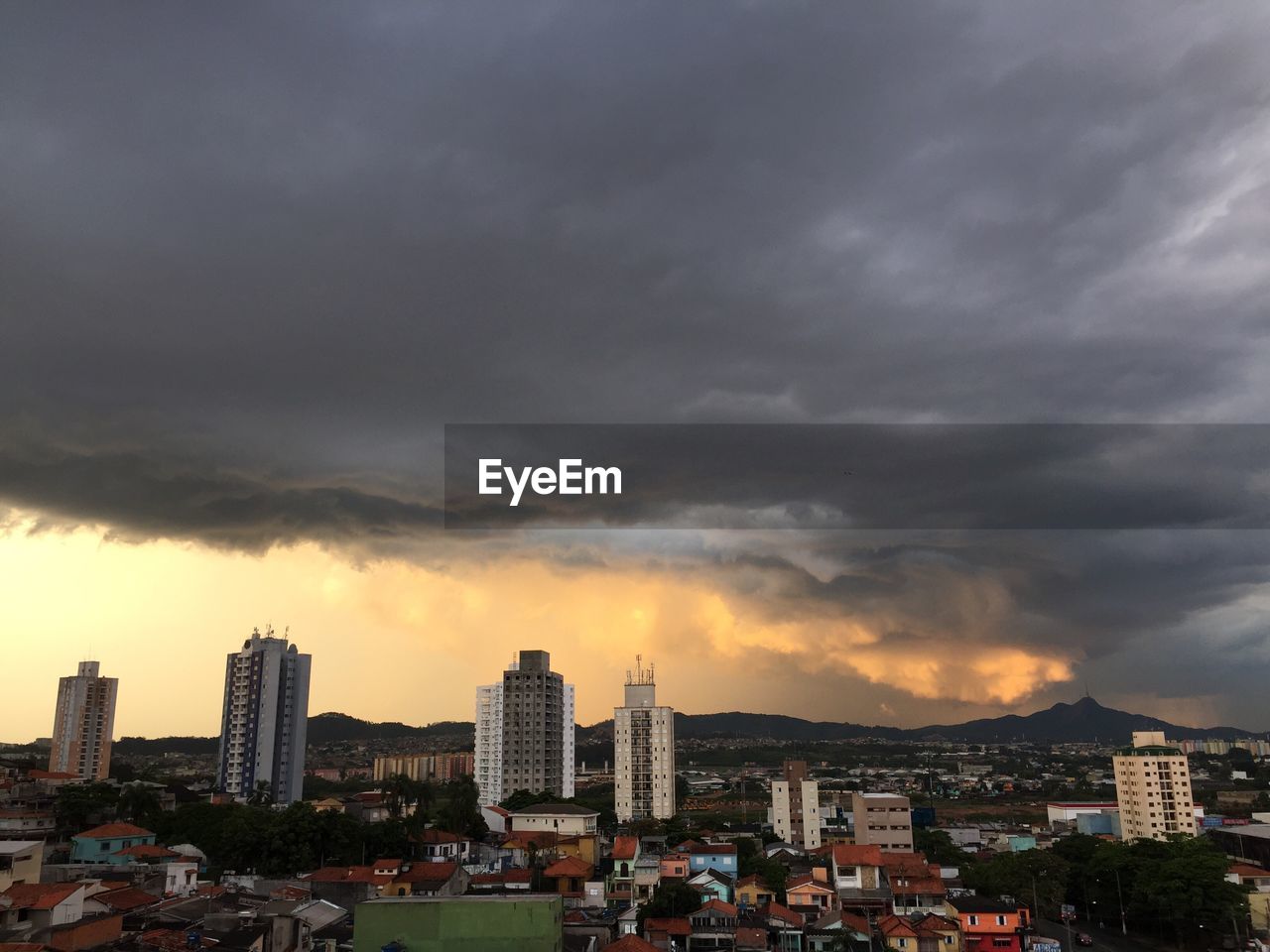 Storm clouds over city at sunset